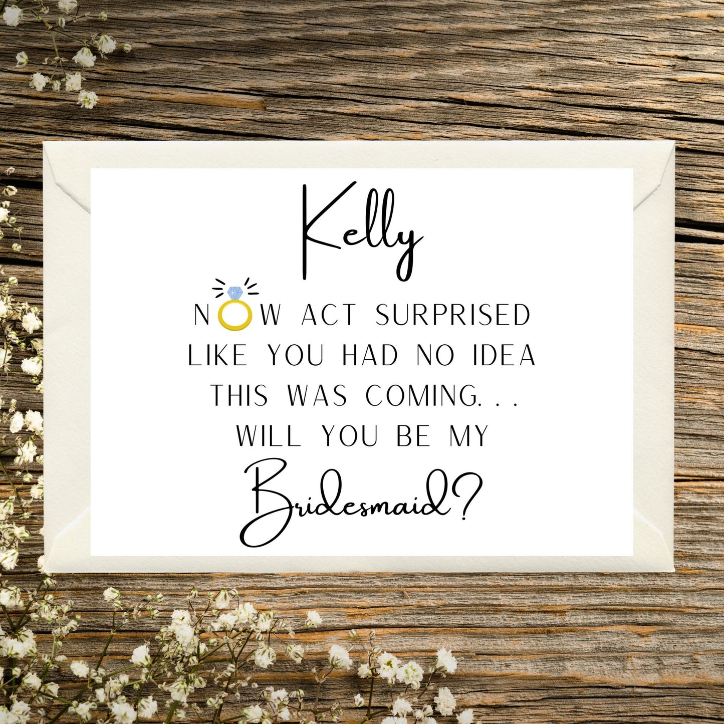 Card asking if you will be my bridesmaid on a wooden surface with flowers.