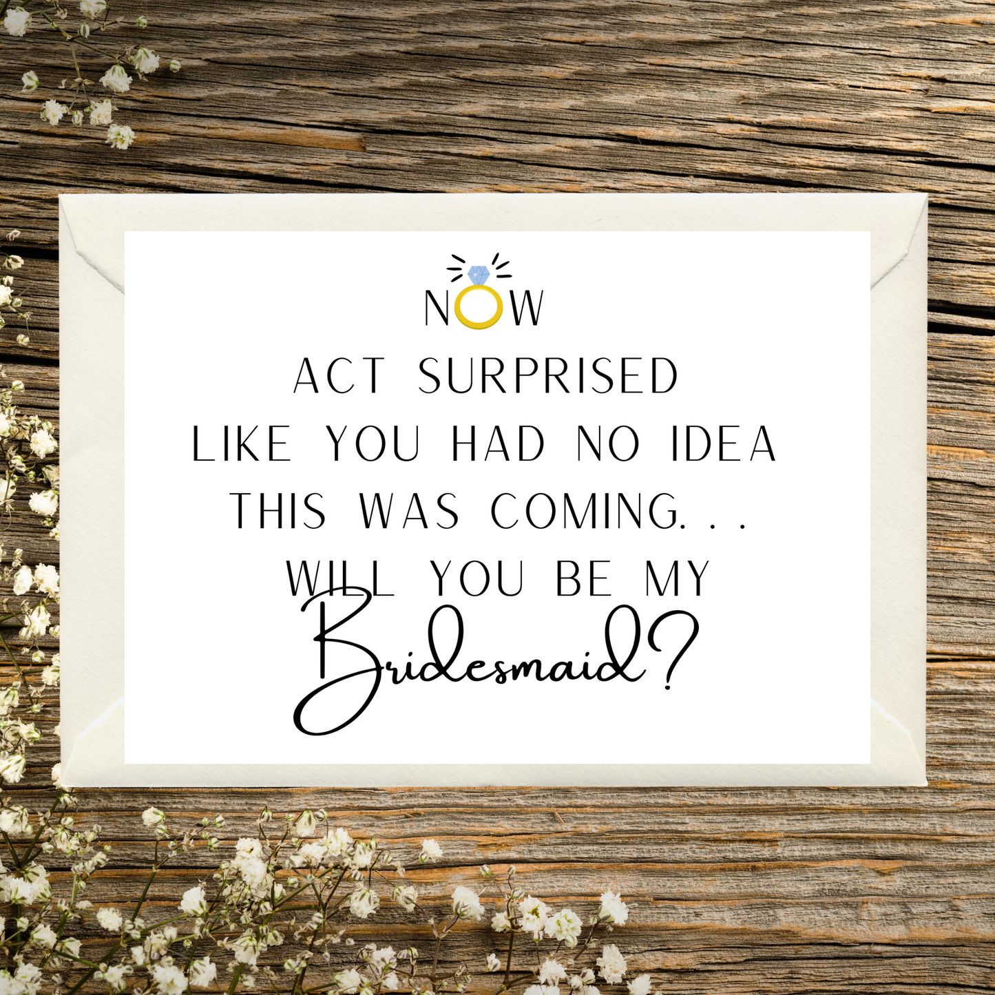 Card asking if you will be my bridesmaid on a wooden surface with flowers.
